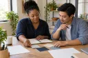 A small-business owner and colleague reviewing blank brand swatches and planning materials.