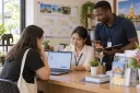 A training-center administrator helps a student enter an enquiry while an advisor discusses the course schedule.